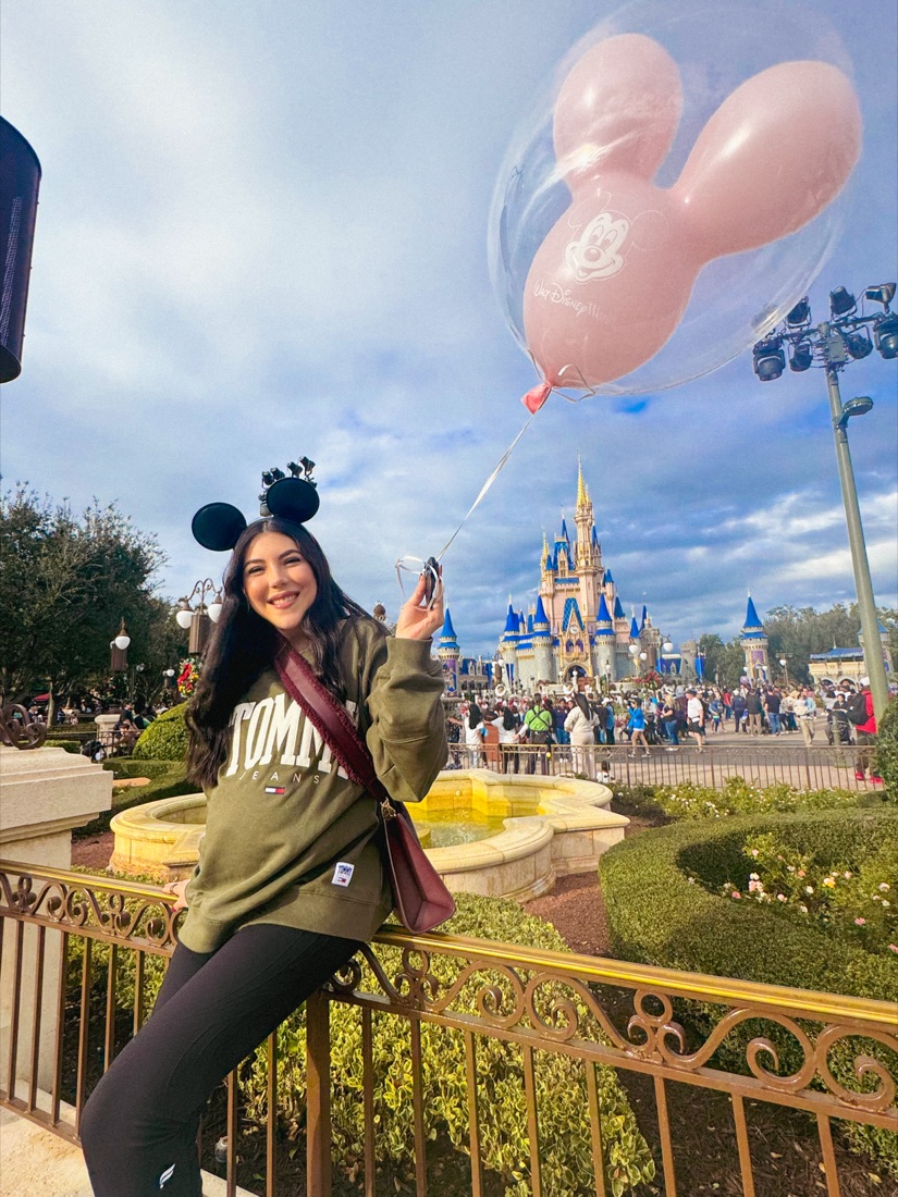 Dani Godinez con globos de Mickey frente al Castillo de Cenicienta en Magic Kingdom, Walt Disney World