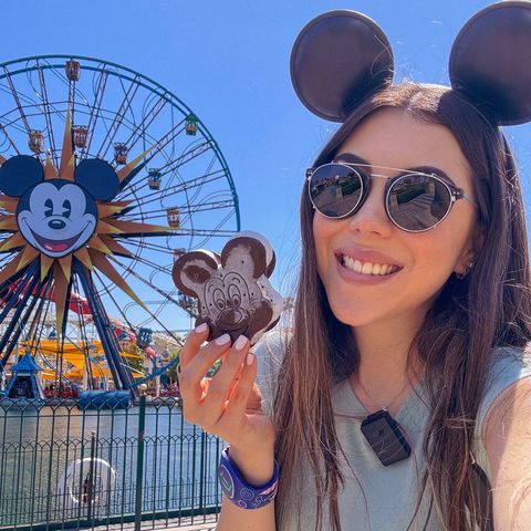 Dani Godinez con un helado de Mickey frente a la rueda de la fortuna de Pixar Pier, Disney California Adventure