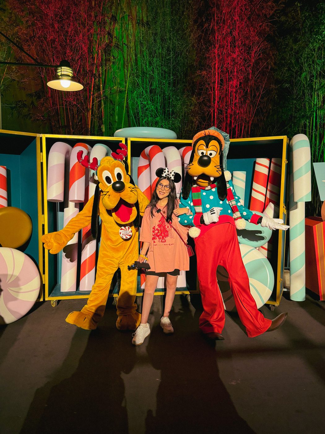 Dani Godinez con Goofy y Pluto, con ropa navideña, en Disney Jollywood Nights.
