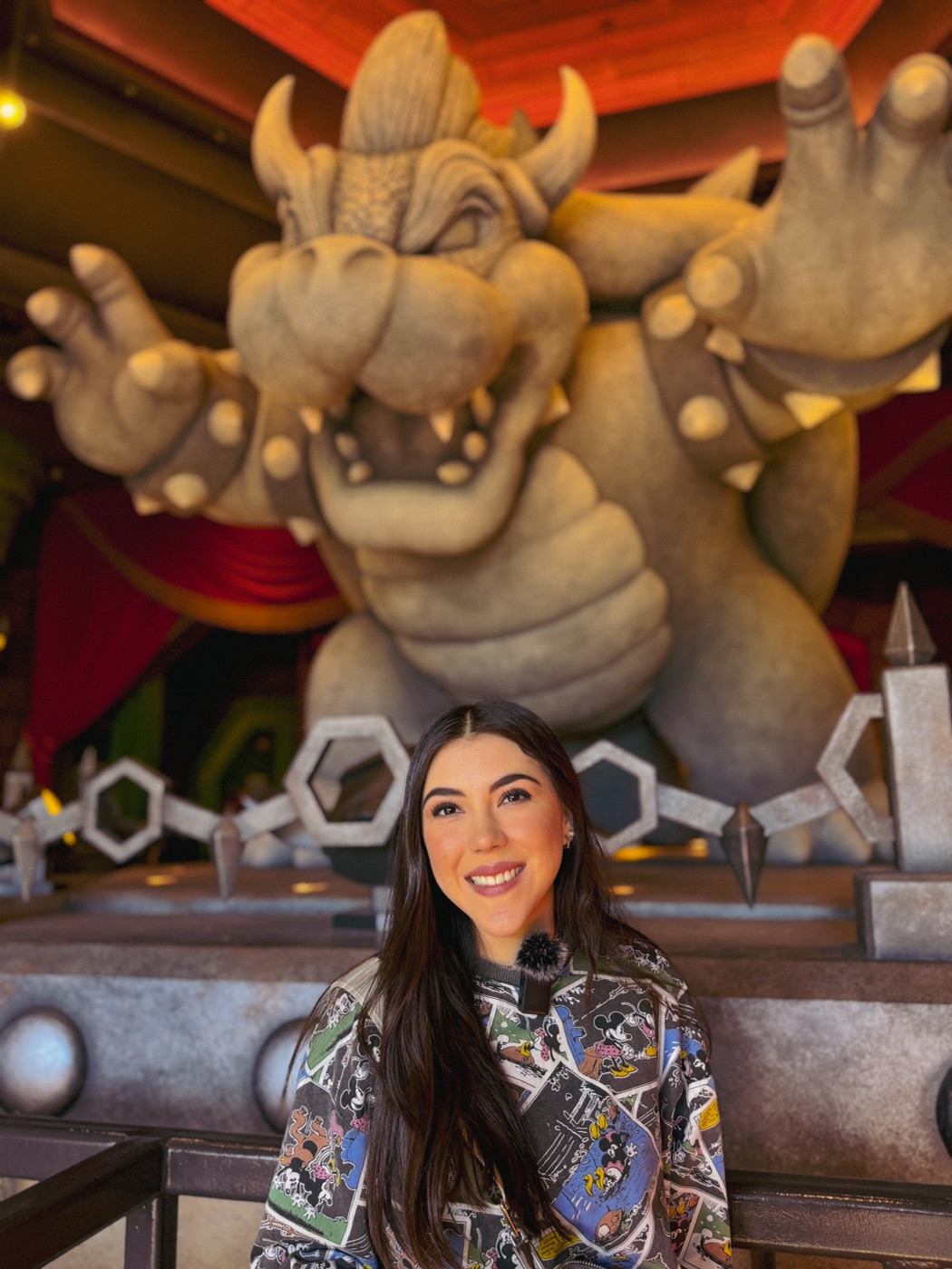 Dani Godinez con la estatua de Bowser en Super Nintendo World, Universal Hollywood